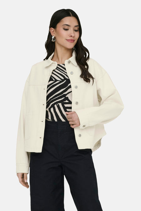 Veste courte écru de JDY, à manches longues, fermeture boutonnée et portée sur un haut à imprimé zèbre et un pantalon noir.