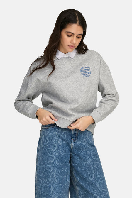 Pull gris ONLY® à col rond et manches longues, avec un petit imprimé bleu sur la poitrine.