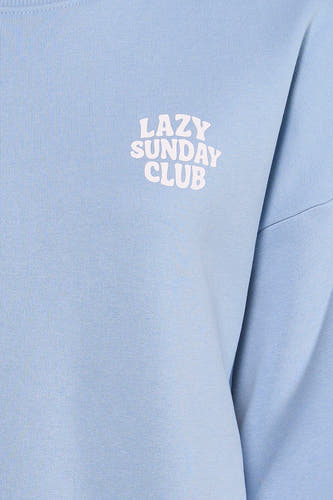 Pull bleu de ONLY® avec l'inscription "Lazy Sunday Club" imprimée dessus.
