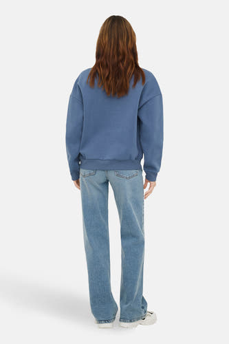 Pull bleu à col rond de ONLY, à manches longues, combiné avec un jean bleu.