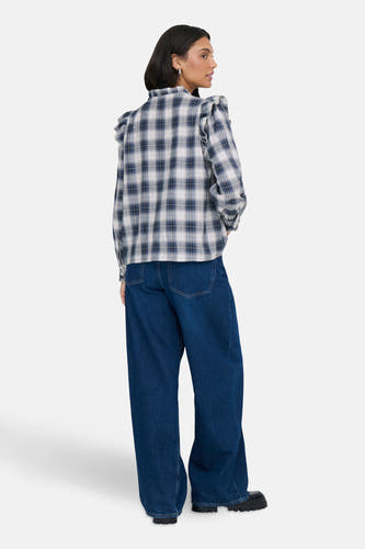 Blouse bleue à manches longues de ONLY, terminée par des volants sur les épaules, associée à des jeans larges.