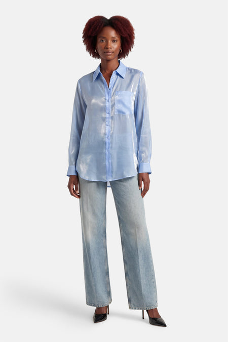 Blauw hemd met lange mouwen van ONLY®, met glanzende textuur, gedragen met wijde jeans en zwarte hakken.
