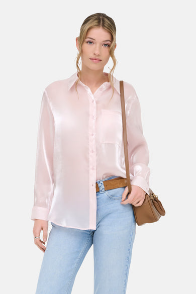 Chemise rose (manches longues) de ONLY®, à manches longues et avec une poche poitrine, combinée avec une ceinture marron et un jean bleu clair.