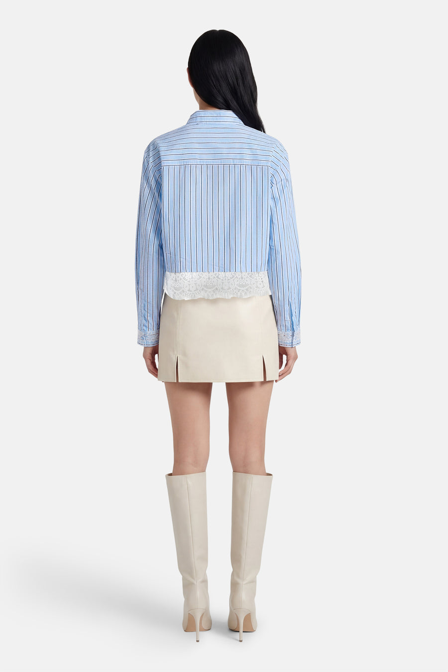 Chemise bleue rayée à manches longues ONLY®, finie avec des détails en dentelle, combinée avec une jupe écru et des bottes.