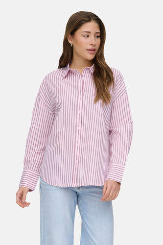 Chemise rose à manches longues ONLY, rayée, associée à un jean ample et des chaussures bleues.