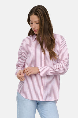 Chemise rose à manches longues ONLY, à motif rayé, portée avec un jean clair.