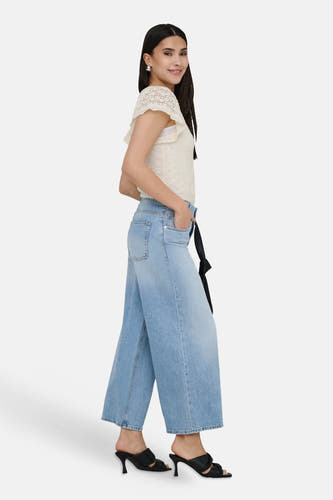 Jeans en denim bleu clair larges ONLY®, coupe ample, stylisées avec un top en crochet et des talons noirs.