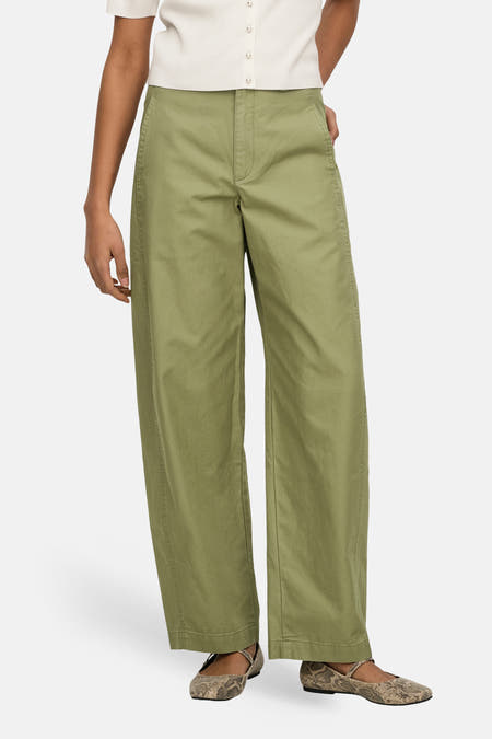 Groene broek van JDY, met wijde pijpen en gedragen met een crèmekleurige top en slangenleren ballerina's.

