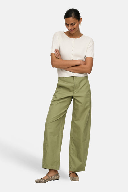 Groene broek van JDY, met wijde pijpen en een casual uitstraling, gecombineerd met een witte top en slangenleren schoenen.
