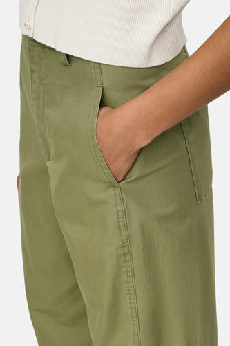Groene broek van JDY, met steekzakken en een ontspannen pasvorm, gecombineerd met een ribgebreide top.
