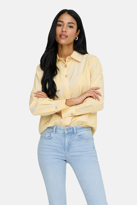 Geel gestreept hemd met lange mouwen van JDY, met decoratieve knopen en lichtblauwe jeans.
