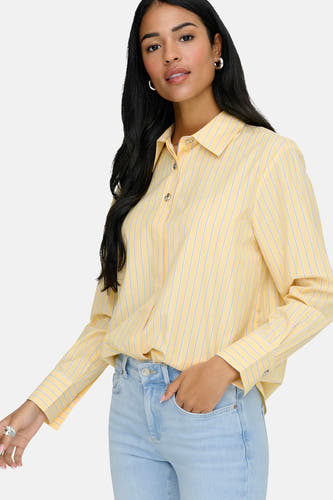 Chemise jaune à rayures à manches longues de JDY avec fermeture boutonnée, portée avec un jean.