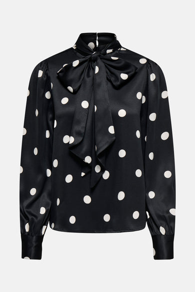 Blouse noire à longues manches de ONLY, avec des taches blanches et un nœud décoratif.