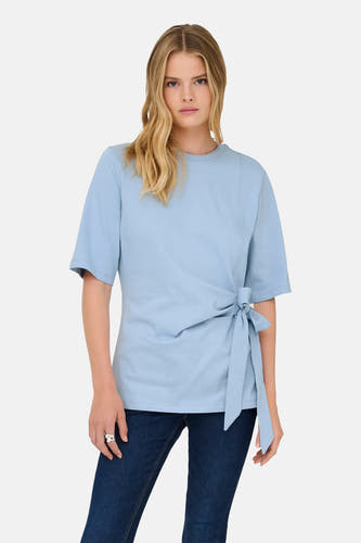 T-shirt bleu à manches courtes de ONLY, avec un détail de bouton sur le côté, à combiner avec un jean foncé et des baskets blanches.