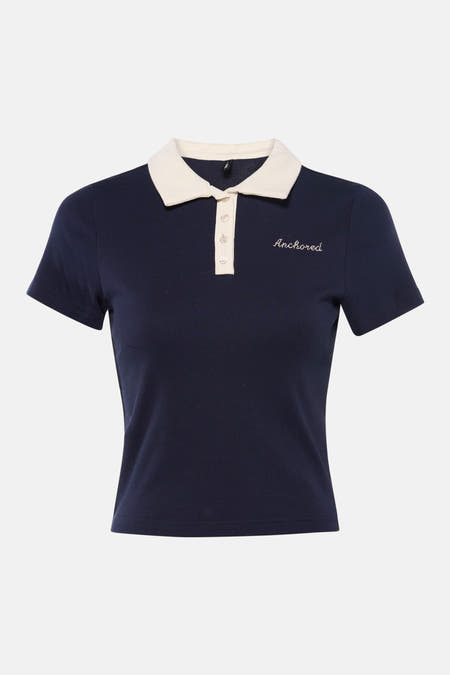 Polo bleu à manches courtes de ONLY, avec col blanc et broderie "Anchored". Le polo est associé à un jean.