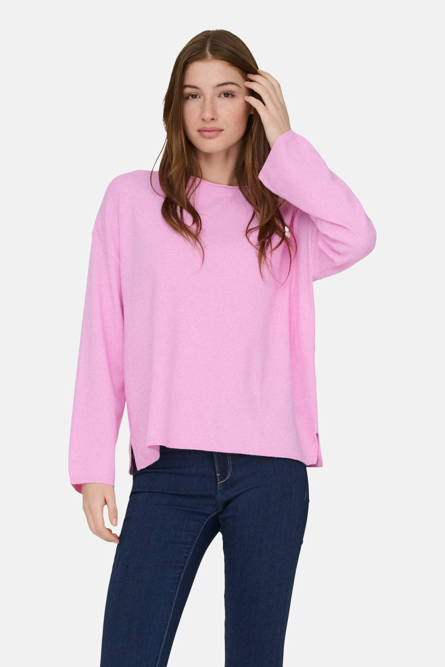 Vrouw in roze trui en blauwe jeans.
