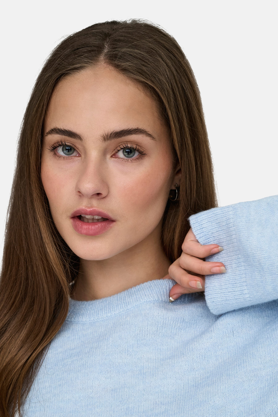 Portret van een vrouw met een blauwe wollen trui.
