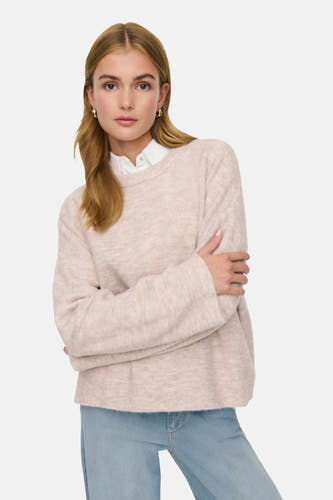 Pull beige à col rond de ONLY®, avec des manches croisées sur le corps et des jeans bleus.