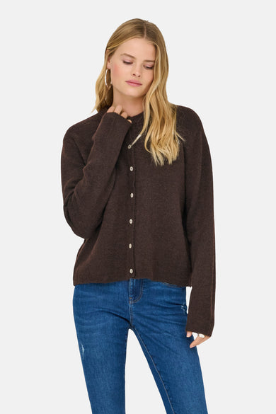 Bruin vest van ONLY, gedragen met een blauwe jeans en zilveren oorringen.
