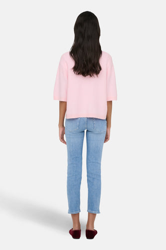 Vrouw van achter, roze trui, jeans, bordeauxrode ballerina's.