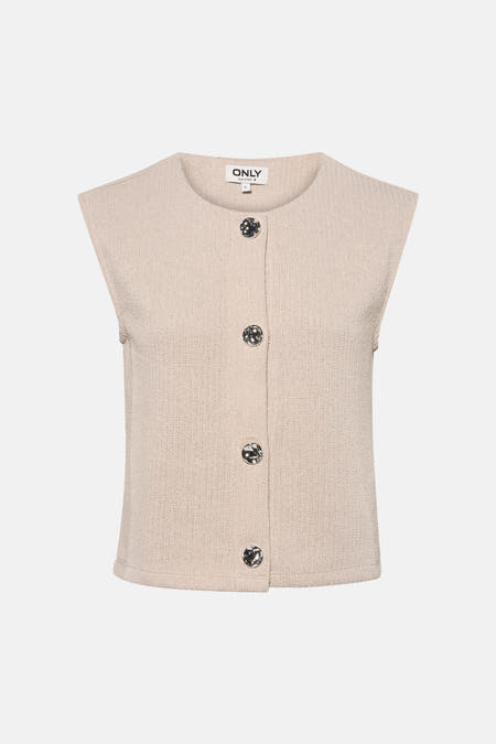 Gilet beige de ONLY, avec boutons, combiné avec un pantalon noir avec ceinture à imprimé animal et des escarpins argentés.