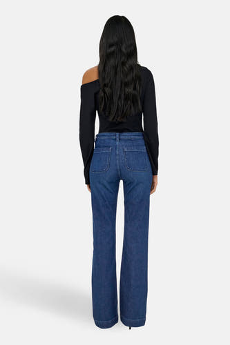 Jean flare bleu marine de ONLY, avec des poches arrière et une coupe ajustée, associé à un haut noir.