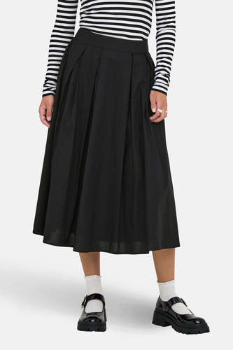 Jupe longue noire ONLY, avec des plis et une longueur midi, portée avec un haut rayé et des chaussures noires.