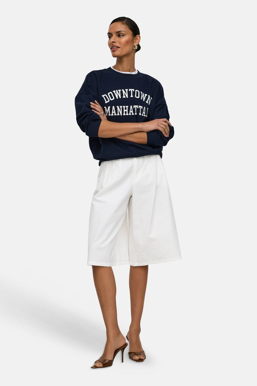 Short blanc de JDY, porté par un mannequin avec un sweat-shirt bleu marine et des mules marron.