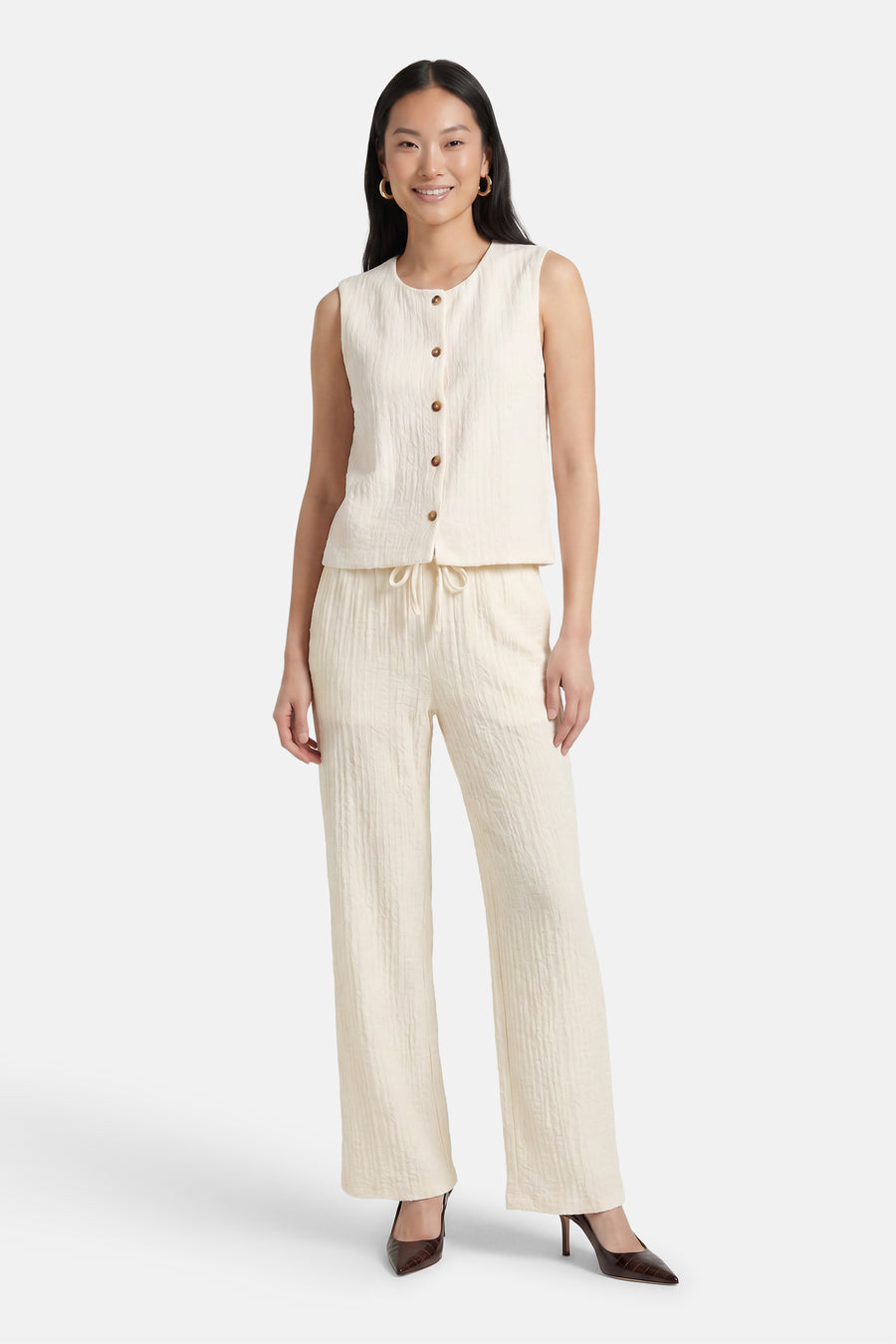 Witte broek van lichte stof met rimpeltextuur van JDY, wijde pijpen, trekkoord taille, vooraanzicht model in lichte top en bruine hakken