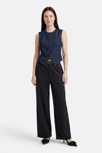 Donkerblauwe mouwloze denim blouse van JDY met ronde hals en knoopsluiting, gecombineerd met zwarte broek.