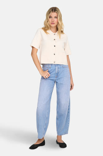 Jeans special fit in lichtblauw denim van ONLY®, met wijde pijpen en gedragen met een crèmekleurig shirt en zwarte schoenen.
