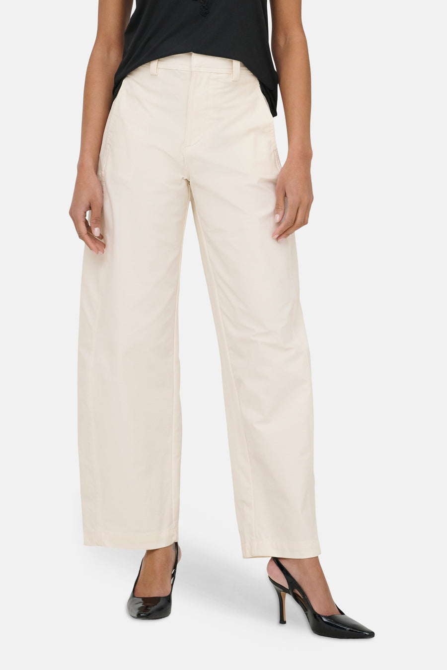 Chino beige de ONLY, avec jambes larges et porté avec un haut noir et des escarpins.
