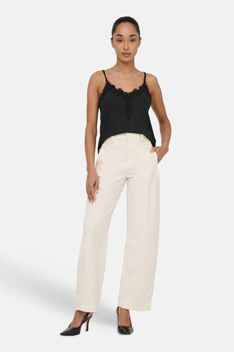 Beige chino van ONLY, met wijde pijpen en gedragen met een zwarte top en pumps.
