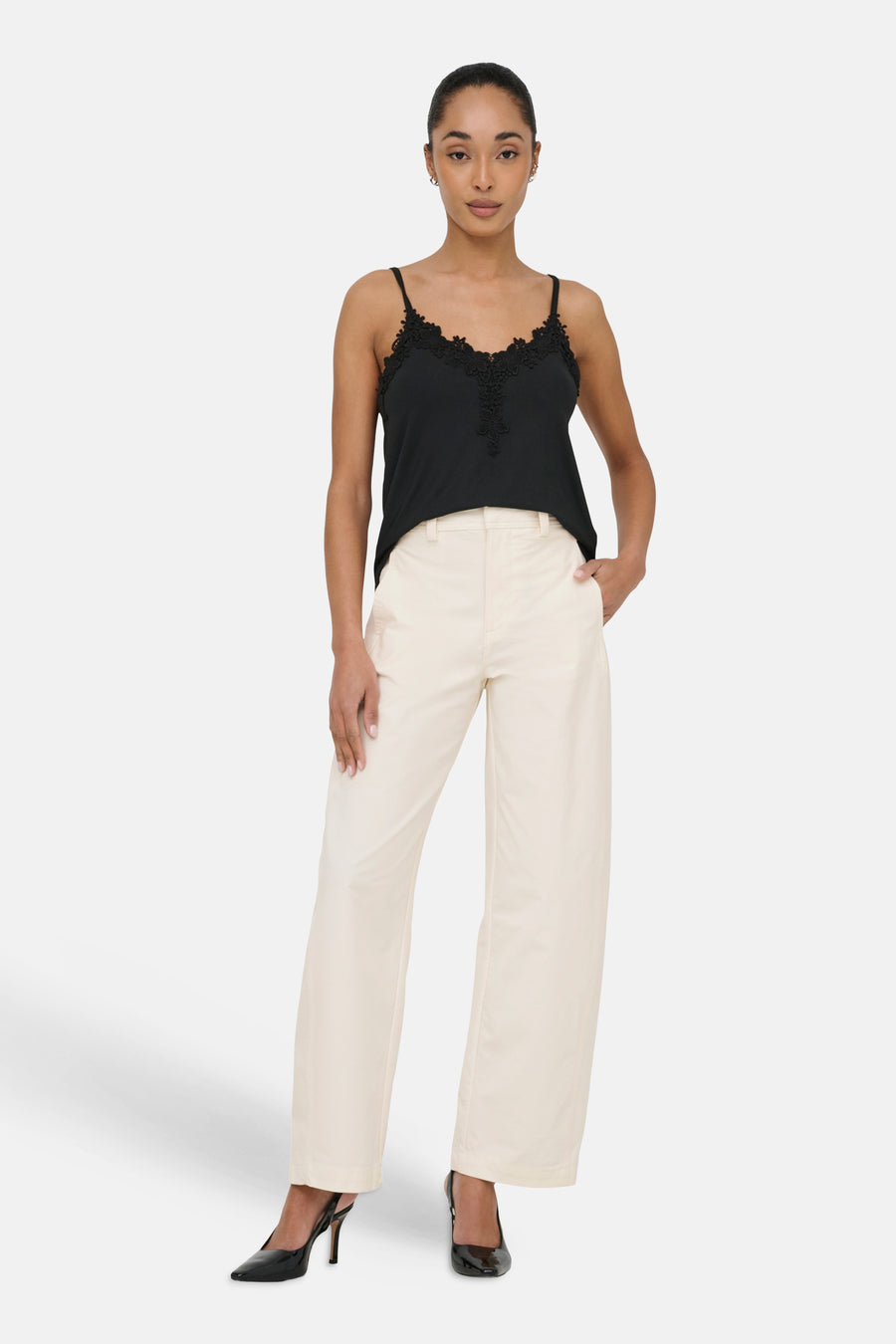 Beige chino van ONLY, met wijde pijpen en gedragen met een zwarte top en pumps.