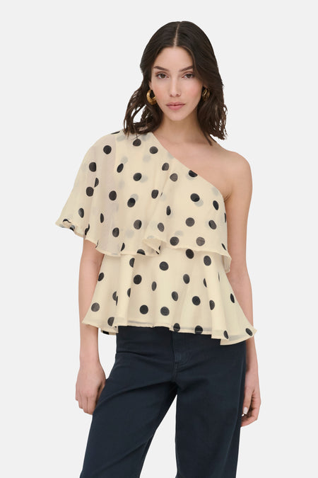 Blouse écru à manches courtes de JDY, avec une épaule dénudée, pois noirs et volants superposés.