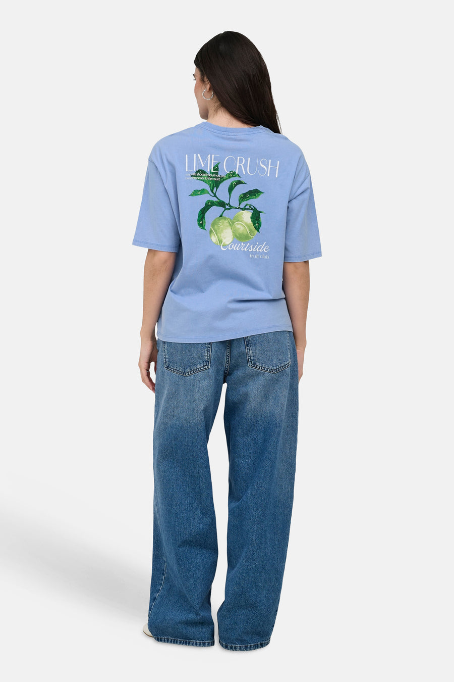 T-shirt bleu ONLY® avec 'Lime Crush' et imprimé citron vert au dos, porté avec un jean.