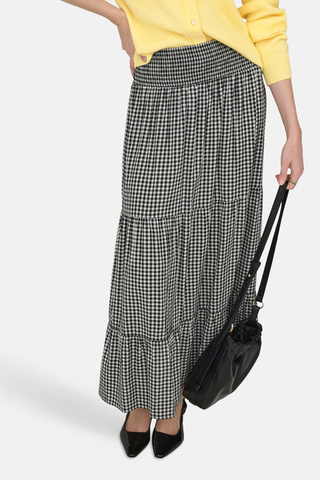 Jupe longue de JDY, avec motif pied-de-poule noir et blanc et design à volants, combinée avec un cardigan jaune et un sac en cuir noir.