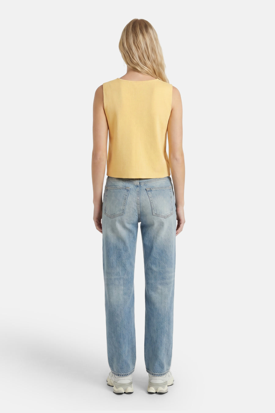 Gele ribbelgilet van ONLY®, achterkant, gedragen met lichtblauwe jeans en witte sneakers