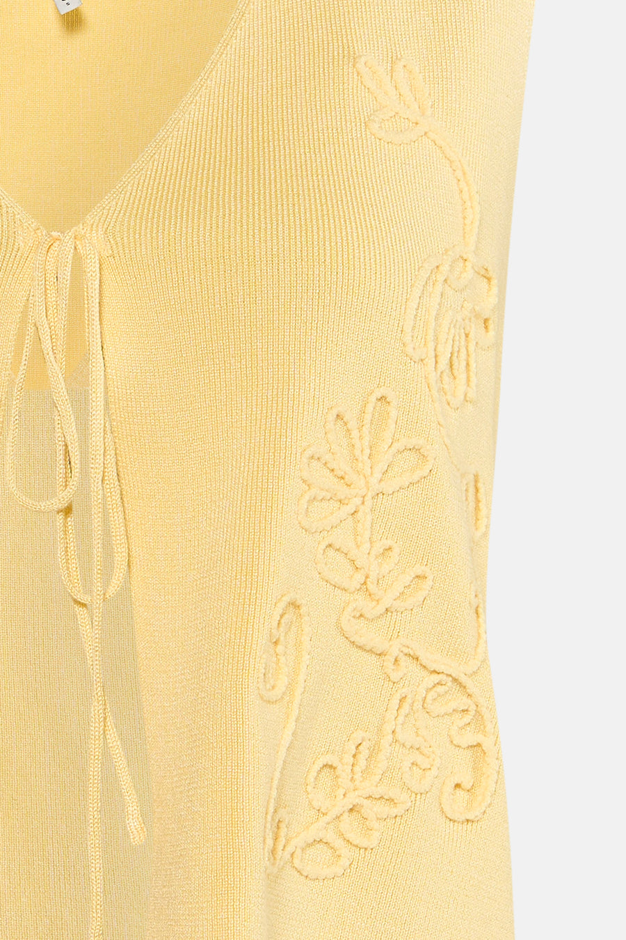 Gele gebreide gilet van ONLY® met bloemenmotief en strikdetail aan de voorkant, close-up weergave