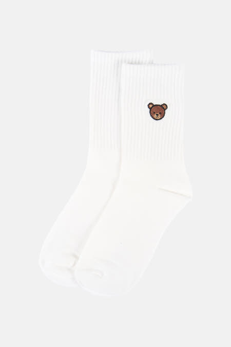 Chaussettes blanches d'ONLY Essentials, avec un petit ours brun brodé.