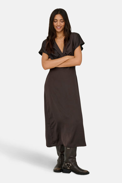 Robe brune à manches courtes de JDY, avec un col V et portée avec des bottes.