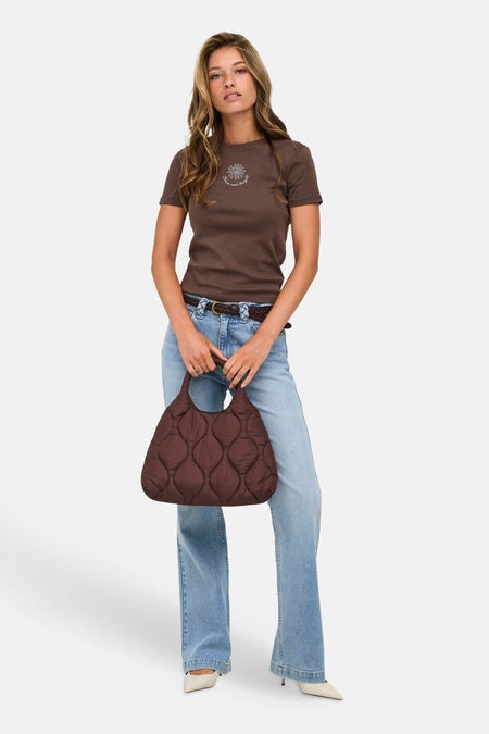 Bruine korte mouwen t-shirt van ONLY® met witte zonprint op borst, gedragen met lichtblauwe jeans en bruine quilted tas, front view