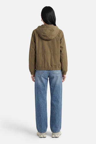 Veste courte verte de JDY, avec capuche, manches longues et portée avec un jean bleu.