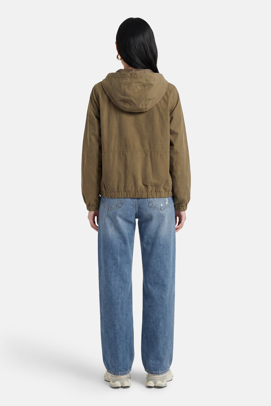 Veste courte verte de JDY, avec capuche, manches longues et portée avec un jean bleu.