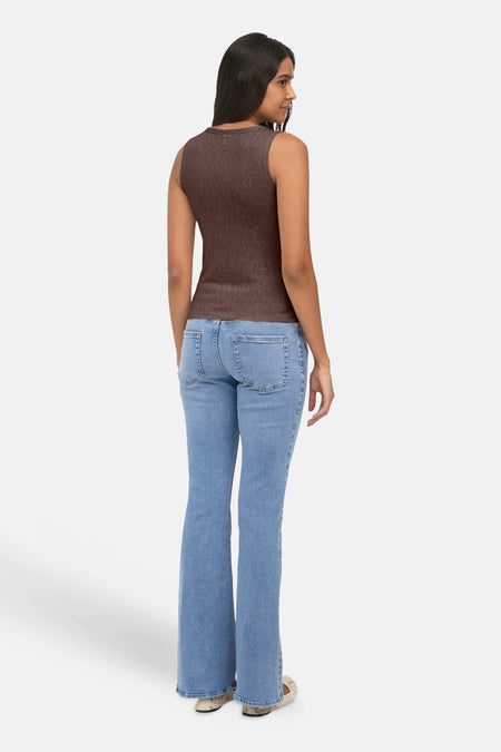 Bruine tanktop van ONLY®, achterkant weergegeven, met gladde stof en strakke pasvorm, gedragen met lichtblauwe flared jeans.