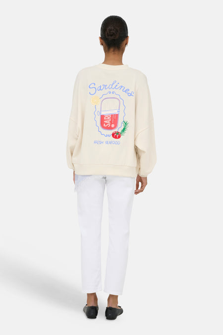 Pull beige de ONLY® avec un imprimé coloré au dos représentant des 'Sardines', une boîte de sardines, du citron et une tomate, au dos.