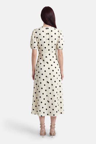 Robe écru à manches courtes de JDY, avec un motif à pois noirs, une fermeture éclair invisible au dos et des talons beiges.