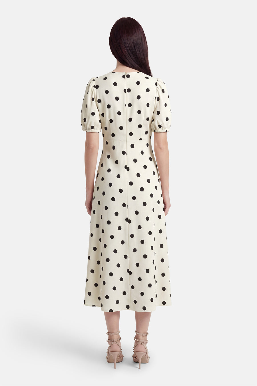 Robe écru à manches courtes de JDY, avec un motif à pois noirs, une fermeture éclair invisible au dos et des talons beiges.