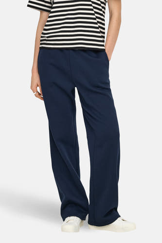 Blauwe joggingbroek van ONLY, gedragen met gestreept shirt en witte sneakers.