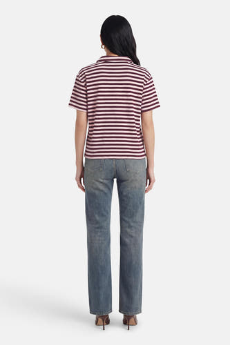 Polo rayée à manches courtes de JDY en rose et bordeaux, portée avec un jean et des talons marron, vue de dos.